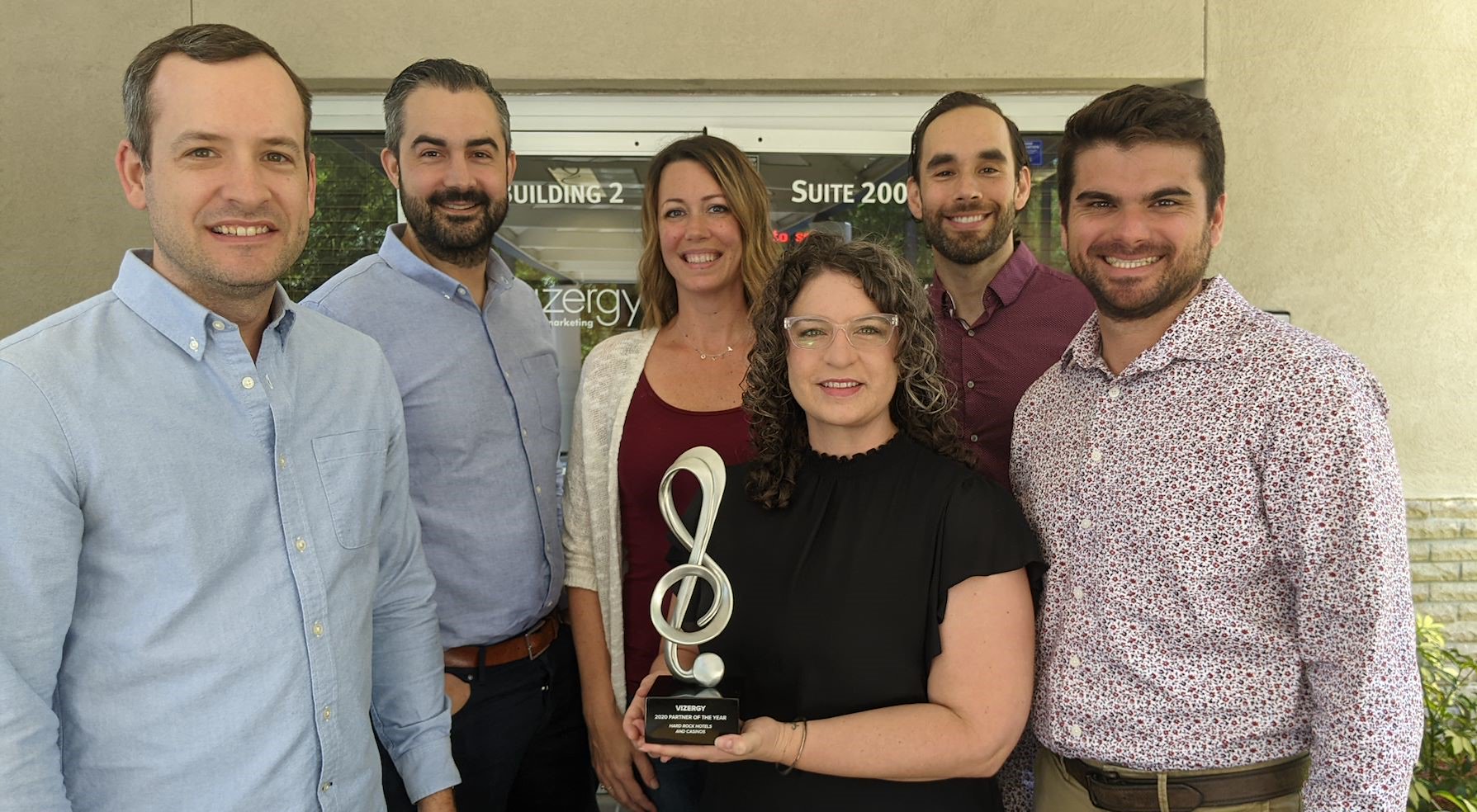 Vizergy Employees Accepting Award Partner of The Year Award from Hard Rock International