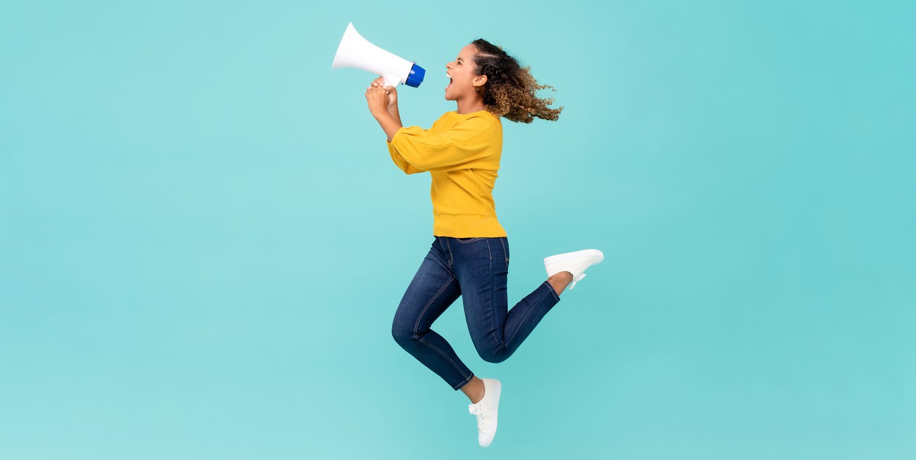 Girl with megaphone jumping and shouting