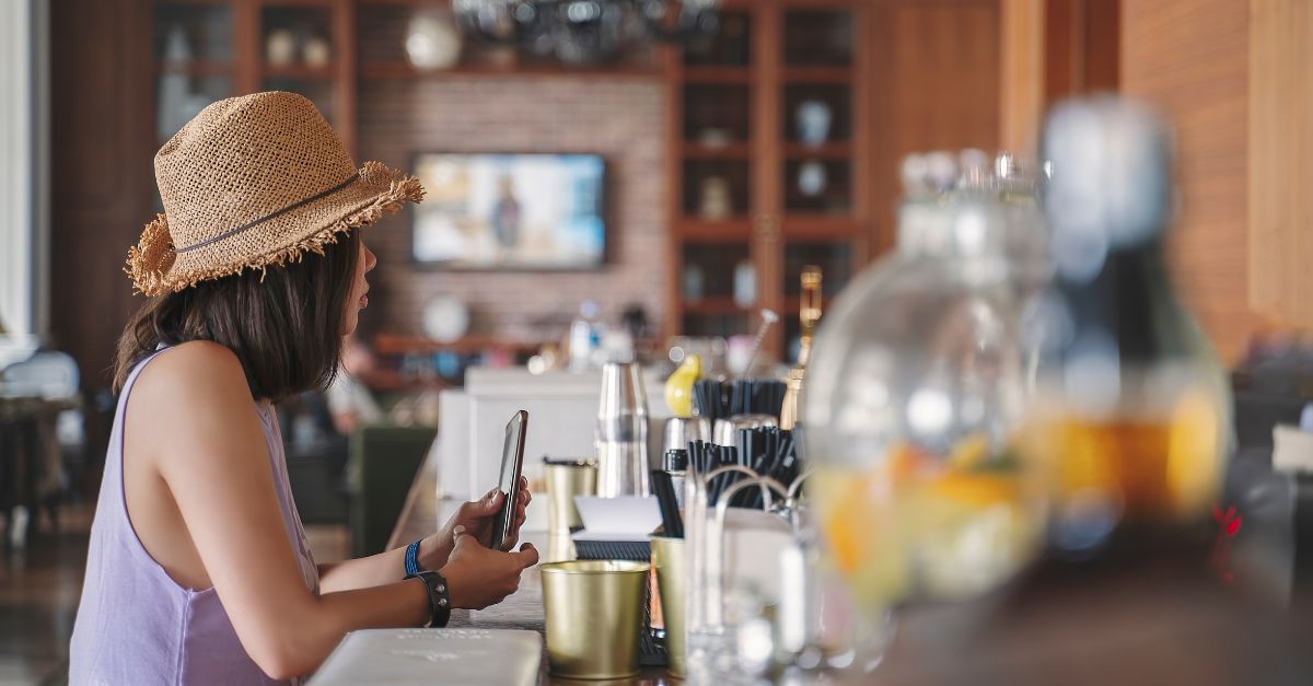 a woman sitting at a bar looking at her phone